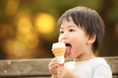 Dışarıda dondurması olan sevimli çocuk.