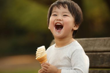 Dışarıda dondurması olan sevimli çocuk.