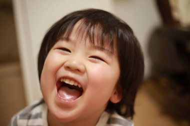 Evde gülen küçük şirin bir çocuğun portresi.