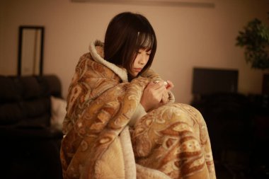 Asyalı kadın vücut ısısını dijital termometreyle kontrol ediyor