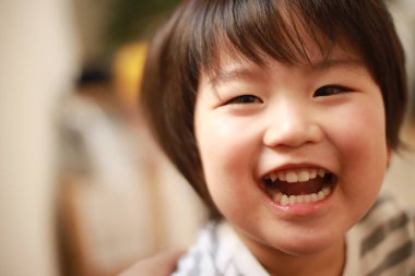 Evde gülümseyen küçük şirin bir çocuğun portresi. 