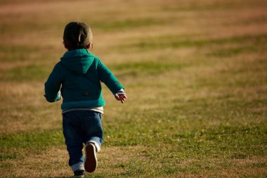 Parkta koşan yakışıklı Asyalı çocuk.