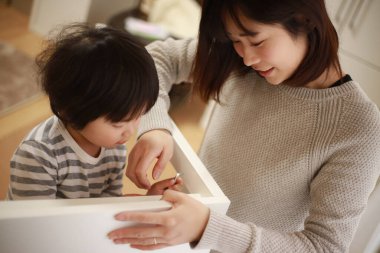 Küçük oğlu olan Asyalı kadın yeni evinde toplanıyor.