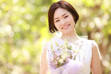 Açık havada gülümseyen güzel bir Asyalı kadının portresi.