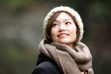 Sonbahar parkında poz veren Asyalı genç kadının portresi. 