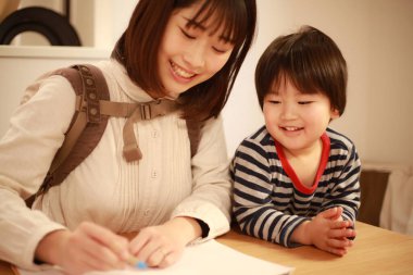 Anne ve kızı küçük oğluyla oynuyorlar.