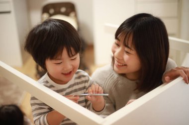 Küçük oğlu olan Asyalı kadın yeni evinde toplanıyor.