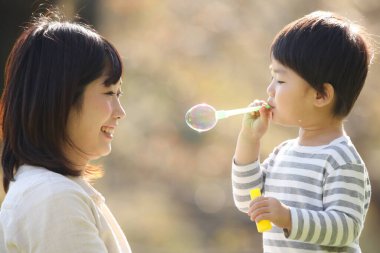 Asyalı anne çocuğuyla oynuyor.