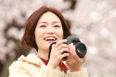 Ormanda kamera tutan genç ve güzel bir kadın.