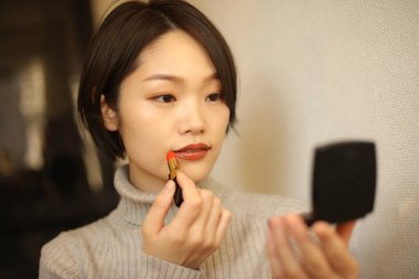 Makyaj yapan güzel bir kadının portresi.