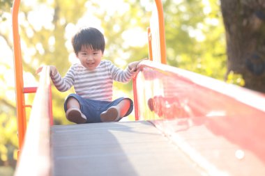 Oyun parkında oynayan sevimli erkek bebek.