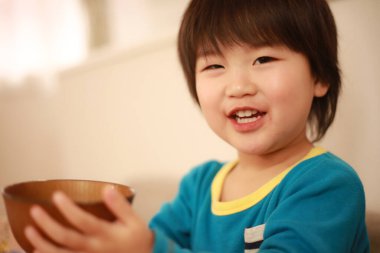 Kahverengi kase tutan küçük şirin bir çocuğun portresi.