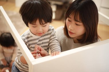 Küçük oğlu olan Asyalı kadın yeni evinde toplanıyor.