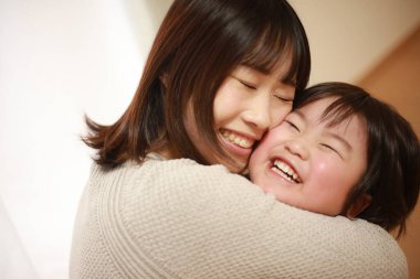 gülümseyen Asyalı genç kadın ve küçük oğlu  