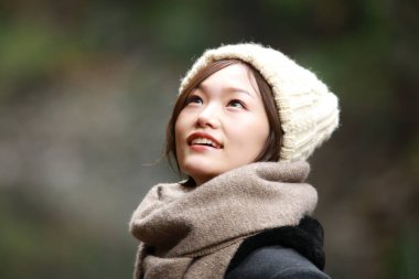 Sonbahar parkında poz veren Asyalı genç kadının portresi. 