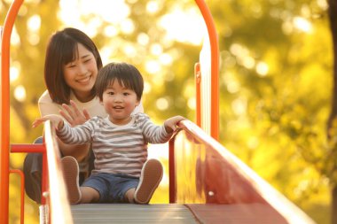 Asyalı anne çocuğuyla oynuyor.