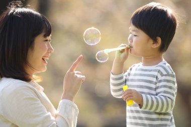 Asyalı anne çocuğuyla oynuyor.