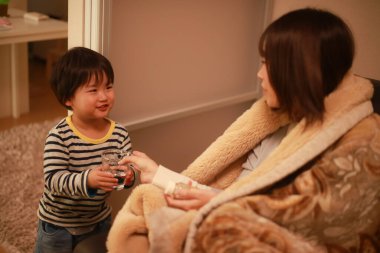 Küçük çocuk hasta annesine yardım ediyor.