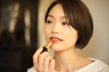 Makyaj yapan güzel bir kadının portresi.