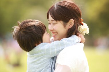 Genç Asyalı anne ve küçük oğlu parkta eğleniyorlar.  