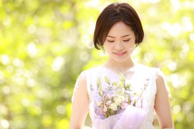 Açık havada gülümseyen güzel bir Asyalı kadının portresi.