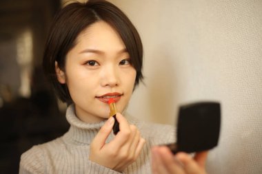 Makyaj yapan güzel bir kadının portresi.