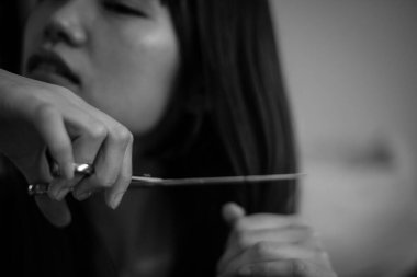 Güzel Asyalı kadın saçını kesiyor. 