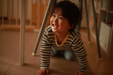 Evde oynayan Asyalı bir çocuğun portresi.