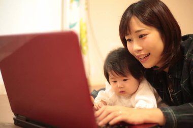 Kadın çocuğuyla birlikte evden çalışıyor.