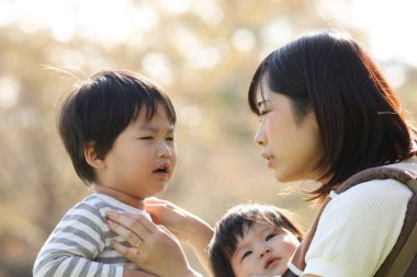 Parkta anneleriyle birlikte Asyalı çocuklar..