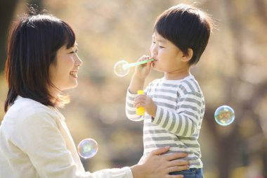 Asyalı anne çocuğuyla oynuyor.