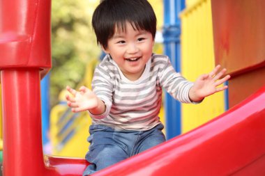 Oyun parkında oynayan sevimli erkek bebek.