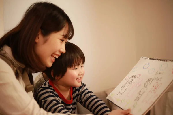 家庭で絵を描く小さな男の子を持つ幸せなアジアの女性 — ストック写真