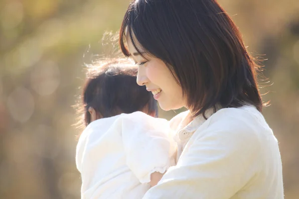 공원에서 귀여운 아기를 데리고 동양인 어머니의 — 스톡 사진
