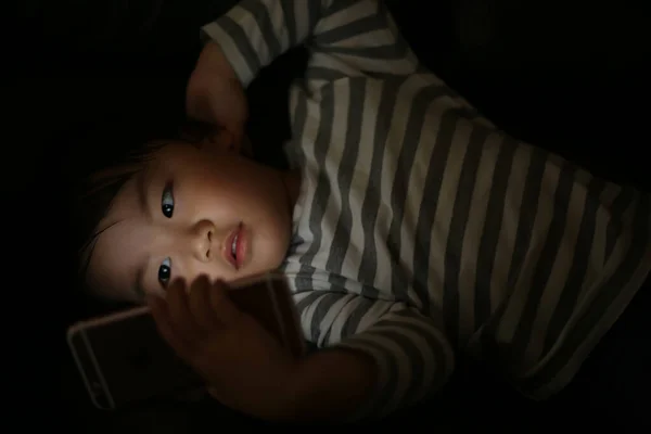 Küçük Çocuk Gece Akıllı Telefon Kullanıyor — Stok fotoğraf
