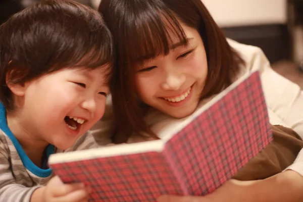 Mutlu Asyalı Anne Oğluna Kitap Okuyor — Stok fotoğraf