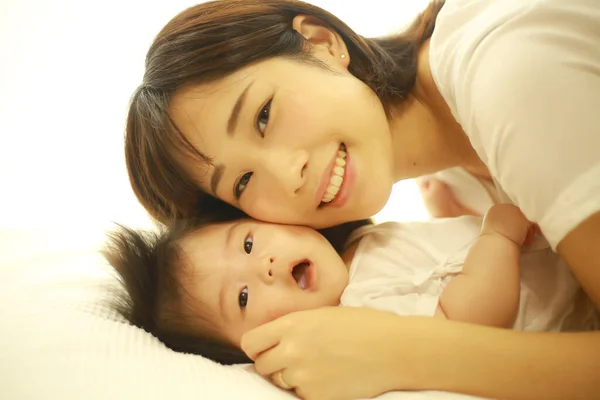 赤ちゃんを持つ若いアジア系女性は — ストック写真
