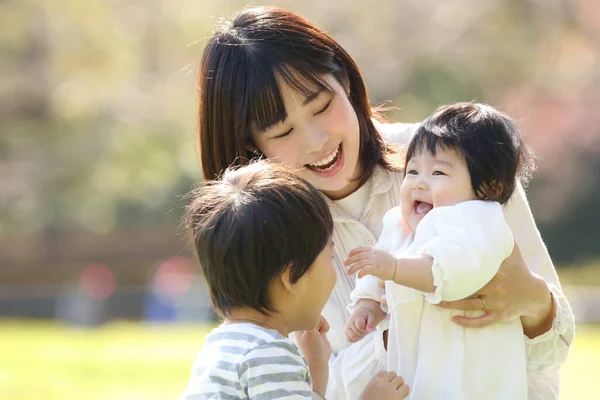 公園で母親と一緒に暮らすアジア系の子供たちは — ストック写真
