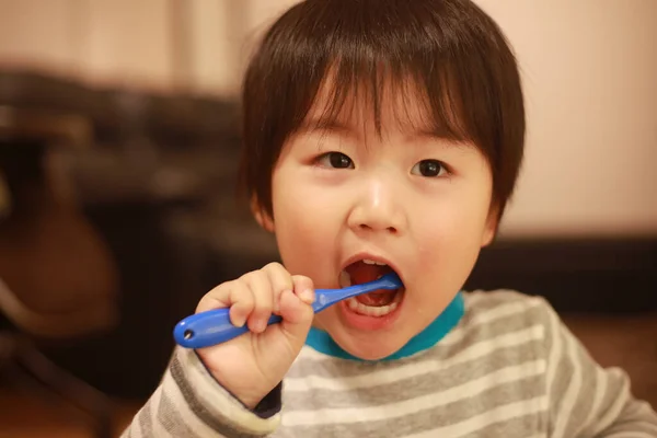 Küçük Japon Çocuk Dişlerini Mavi Diş Fırçasıyla Fırçalıyor — Stok fotoğraf