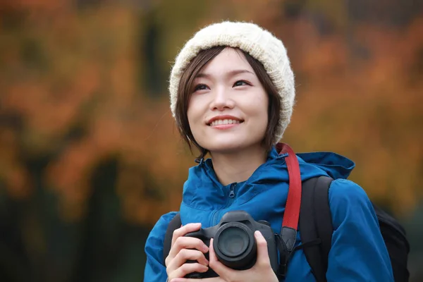 秋の公園で写真を撮る若いアジア人女性の肖像画 — ストック写真