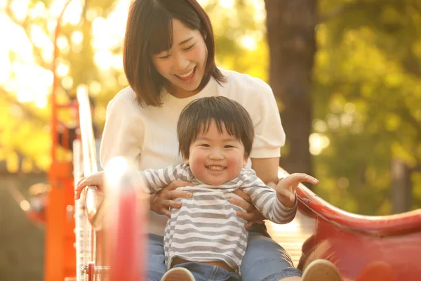 Asyalı anne çocuğuyla oynuyor.