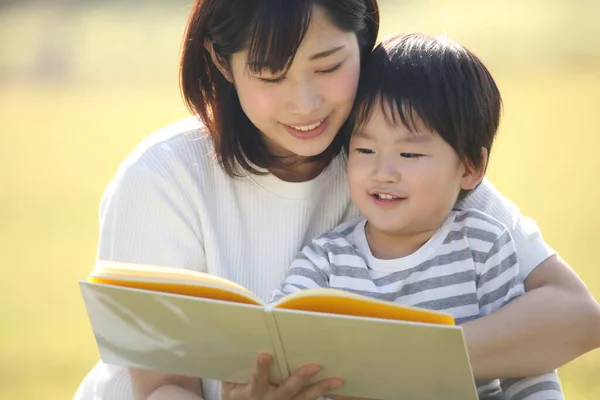 Szczęśliwy Azji Matka Czytania Książki Dla Jej Syn — Zdjęcie stockowe