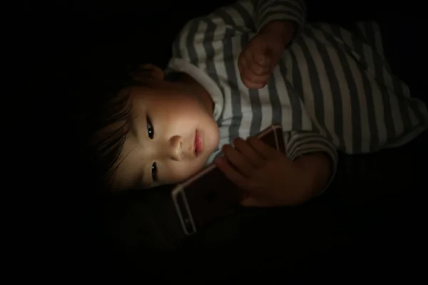 Mały Chłopiec Pomocą Smartfona Nocy — Zdjęcie stockowe