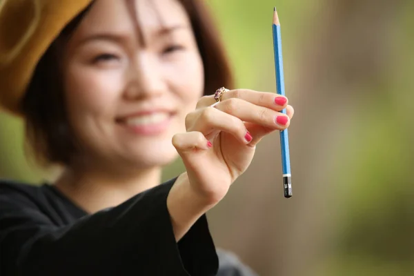 年轻的亚洲女人在公园里给铅笔的肖像 — 图库照片