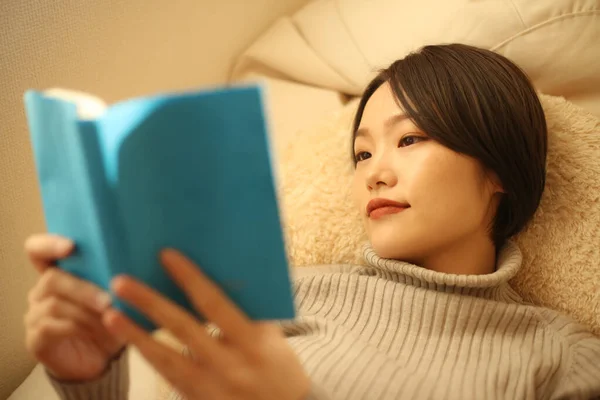 Красивая Женщина Читает Книгу Лежа Диване — стоковое фото