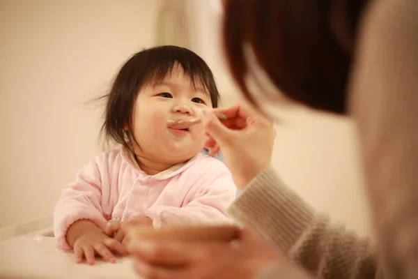 Junge Asiatische Mutter Füttert Ihre Kleine Tochter Mit Einem Löffel — Stockfoto