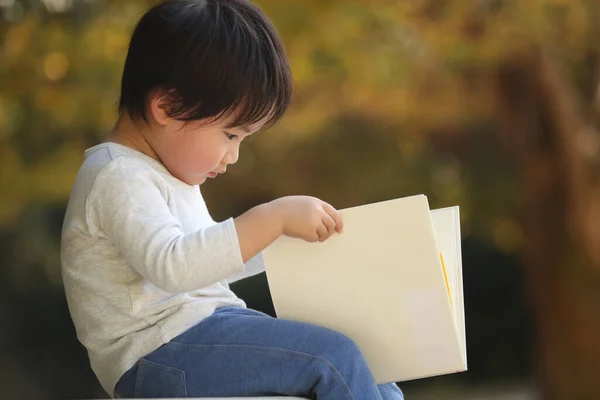 Schattig Baby Jongen Een Park Met Boek — Stockfoto