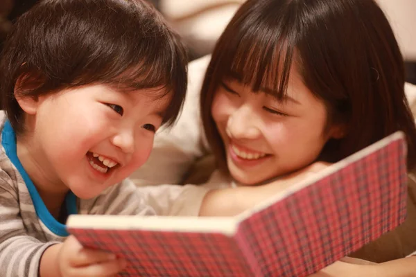 Счастливая Азиатская Мать Читает Книгу Своему Сыну — стоковое фото