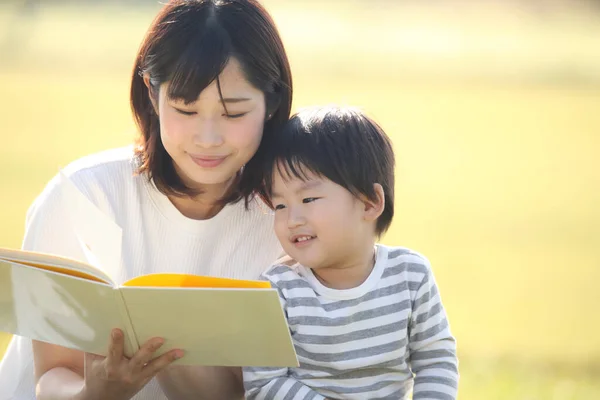 Szczęśliwy Azji Matka Czytania Książki Dla Jej Syn — Zdjęcie stockowe