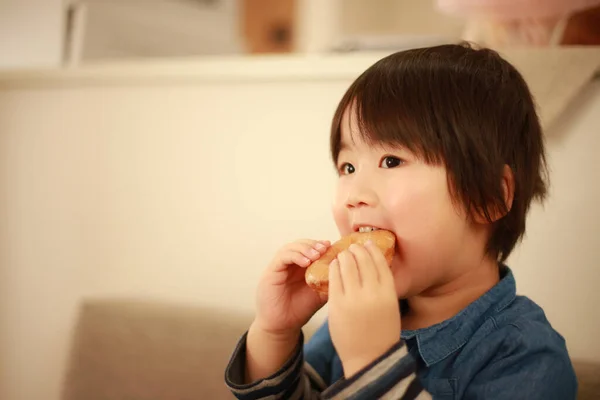 Kleiner Junge Isst Leckeren Donut Hause — Stockfoto